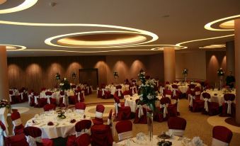 a large banquet hall with numerous tables and chairs set up for a formal event , possibly a wedding reception at Central Plaza Hotel