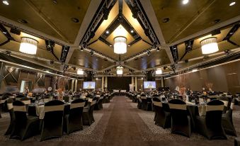 a large , well - lit banquet hall with multiple tables and chairs arranged for a formal event at Mercure Sydney Bankstown