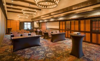 a large conference room with multiple tables and chairs arranged for a meeting or event at The Craftsman Inn & Suites