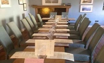 a long dining table set for a formal dinner , with numerous plates and utensils arranged on it at The Anchor Inn