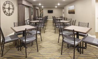 a dining area with multiple tables and chairs , some of which are occupied by people at Grandstay Hotel Suites Thief River Falls