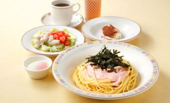 A table is filled with plates and bowls of food, including meat, cheese, and other items at Richmond Hotel Tokyo Suidobashi