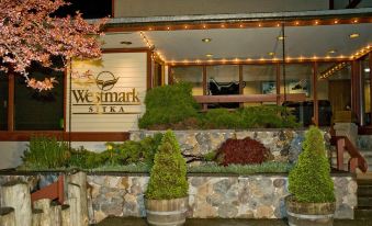 "a building with a sign that says "" westmark siska "" is surrounded by potted plants and flowers" at Southeast Resort