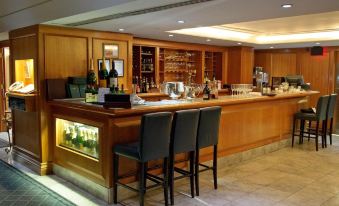 a well - equipped bar area with several bottles and wine glasses , as well as a dining table and chairs at The Waterside Inn