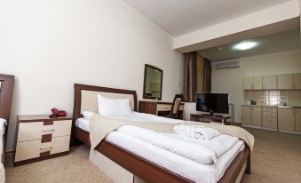 a neatly made bed with white linens and a wooden headboard in a hotel room at Alma