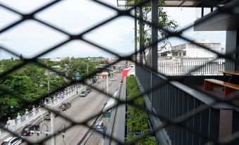 a view of a city street through a chain - link fence , with buildings and traffic visible in the distance at Slive Hotel