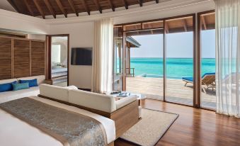a spacious bedroom with a king - sized bed and a large window overlooking the ocean , providing a serene and tranquil atmosphere at Anantara Dhigu Maldives Resort - Special Offer on Transfer Rates for Summer 2024