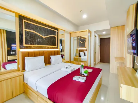 Wood Accents Studio at Grand Dharmahusada Lagoon Apartment by Travelio