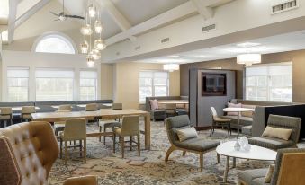 a large dining room with multiple tables and chairs arranged for a group of people to enjoy a meal together at Residence Inn Boston Foxborough