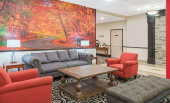 a modern office interior with a large abstract painting , multiple couches , and chairs arranged in a seating area at Ramada by Wyndham Cumberland Downtown