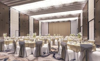 a large banquet hall with white tablecloths , chairs , and flowers is set up for a formal event at Divalux Resort and Spa Bangkok, Suvarnabhumi Airport-Free Shuttle