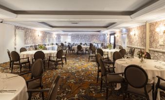 a large , well - decorated room with multiple tables and chairs set up for a formal event or gathering at Marine Troon