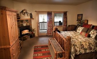 a cozy bedroom with a large bed and a fireplace , creating a warm and inviting atmosphere at Daniels Summit Lodge