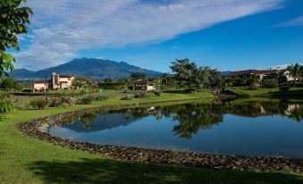 a serene landscape with a house , trees , and a lake , with a mountain in the background at Hacienda Los Molinos Boutique Hotel & Villas