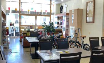 a dining room with several tables and chairs , as well as a variety of bicycles parked outside at Cottage Sunset-Village