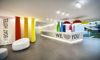 "a modern , well - lit office space with a white reception desk and a sign that says "" we love you ""." at Love Boat Hotel - the Original