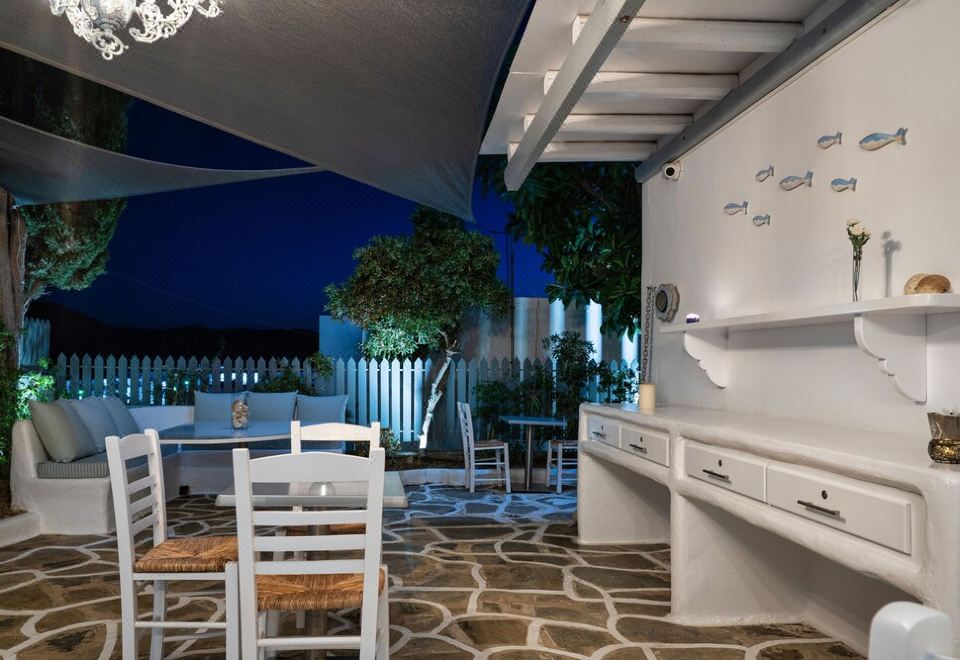 a white kitchen with a dining table and chairs , as well as a covered patio area with outdoor furniture at Hotel Iris