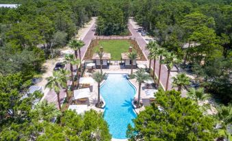 a bird 's eye view of a resort with a pool surrounded by lush greenery and trees at Magnolia Cottages by the Sea by Panhandle Getaways