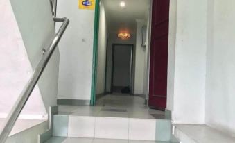 a set of stairs leading to a room with a green door and a red door at Hotel Seri Kangsar KK Hotel