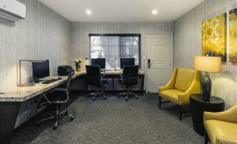 a room with three computer desks , two of which are equipped with monitors and keyboards at Best Western Plus Carriage Inn