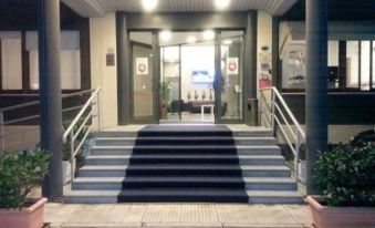 a blue and white striped rug is placed on the steps of a building , leading to an open door at Hotel Touring