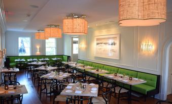 a well - decorated restaurant with multiple dining tables and chairs arranged for guests to enjoy their meal at Topping Rose House