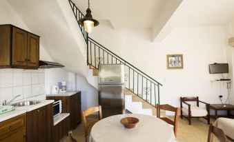 a kitchen with a dining table and chairs , as well as a staircase leading to the second floor at Olive Tree