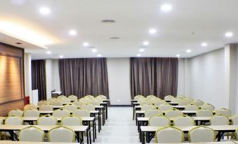 a large conference room with rows of chairs arranged in a semicircle , and a podium at the front of the room at The Gem Hotel Beaufort