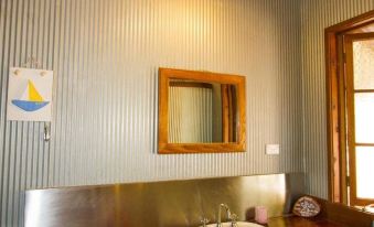 a bathroom sink with a wooden framed mirror on the wall and a mirror above it at 1770 Beach Shacks