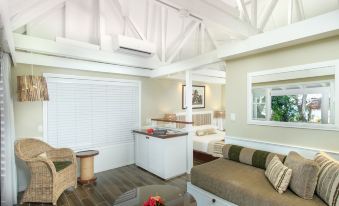 a spacious living room with a couch , dining table , and a kitchen area in the background at Malolo Island Resort