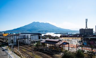 a train station with a view of a mountain and the surrounding landscape , as well as a mountain in the background at Volcano