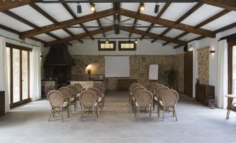 a large room with a wooden ceiling and chairs set up for a meeting or presentation at Monnaber NOU Finca Hotel & Spa