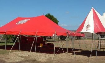 a red and white tent is set up in a field with a clear blue sky overhead at Gowrie Hotel Motor Inn