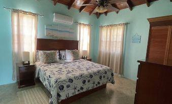 a bedroom with a wooden ceiling and walls , featuring a bed with white and blue bedding at Ocean View Villas