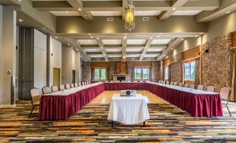 a large conference room with red curtains , white table and chairs , and a ceiling - high ceiling at Hotel & Spa Mont Gabriel