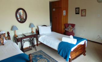 a bedroom with two beds , one of which is made with blue and white sheets , and a wooden desk at Whale Watchers Inn