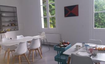 a modern kitchen and dining area with white chairs , a table , and blue tables , along with a window at Chateau Saint Martin B&B