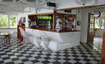 a white and black checkered floor in a restaurant , with a counter and bar area at Driftwood Resort