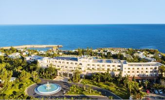 aerial view of a large white hotel surrounded by palm trees , located near the ocean at Iberostar Selection Creta Marine