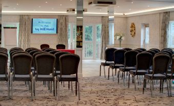 a conference room with chairs arranged in rows and a projector screen on the wall at Best Western Ivy Hill Hotel