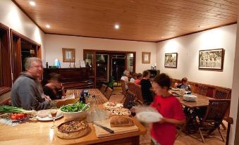 a group of people gathered around a dining table in a restaurant , enjoying a meal together at Bilpin Country Lodge