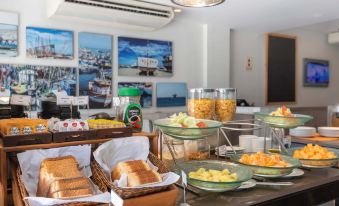 a dining table with a variety of food items , including bread , fruit , and other snacks at Casa Andina Standard Talara