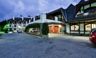 a large white building with a parking lot in front of it , illuminated at night at Hotel Home Green Home