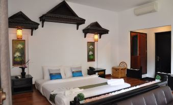 a large bed with white linens is in a room with wooden floors and three wooden shelves at Vimean Sovannaphoum Resort