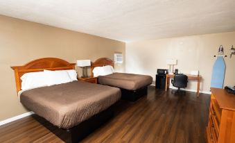 a hotel room with two beds , wooden flooring , and a desk area near the ceiling at Oxford Inn