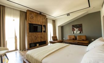 a large bed with a wooden headboard and footboard is in the middle of a room with two brown chairs at Hotel Fantasy