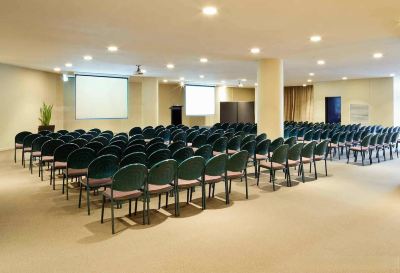 a large conference room with rows of chairs arranged in a semicircle , ready for an event at Ibis Melbourne Hotel and Apartments