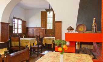 a room with wooden furniture , including tables and chairs , and an orange cabinet on a table at Las Mercedes