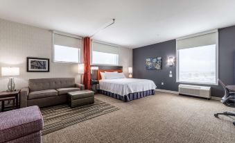 a hotel room with a large bed , couch , and other furniture , as well as a window overlooking the ocean at Home2 Suites by Hilton Fort Worth  Northlake