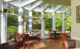 a dining room with a large glass wall , allowing natural light to fill the space at Copper Beech Inn